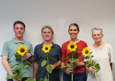 Vorstand mit Sonnenblumen vor einer weißen Wand.
